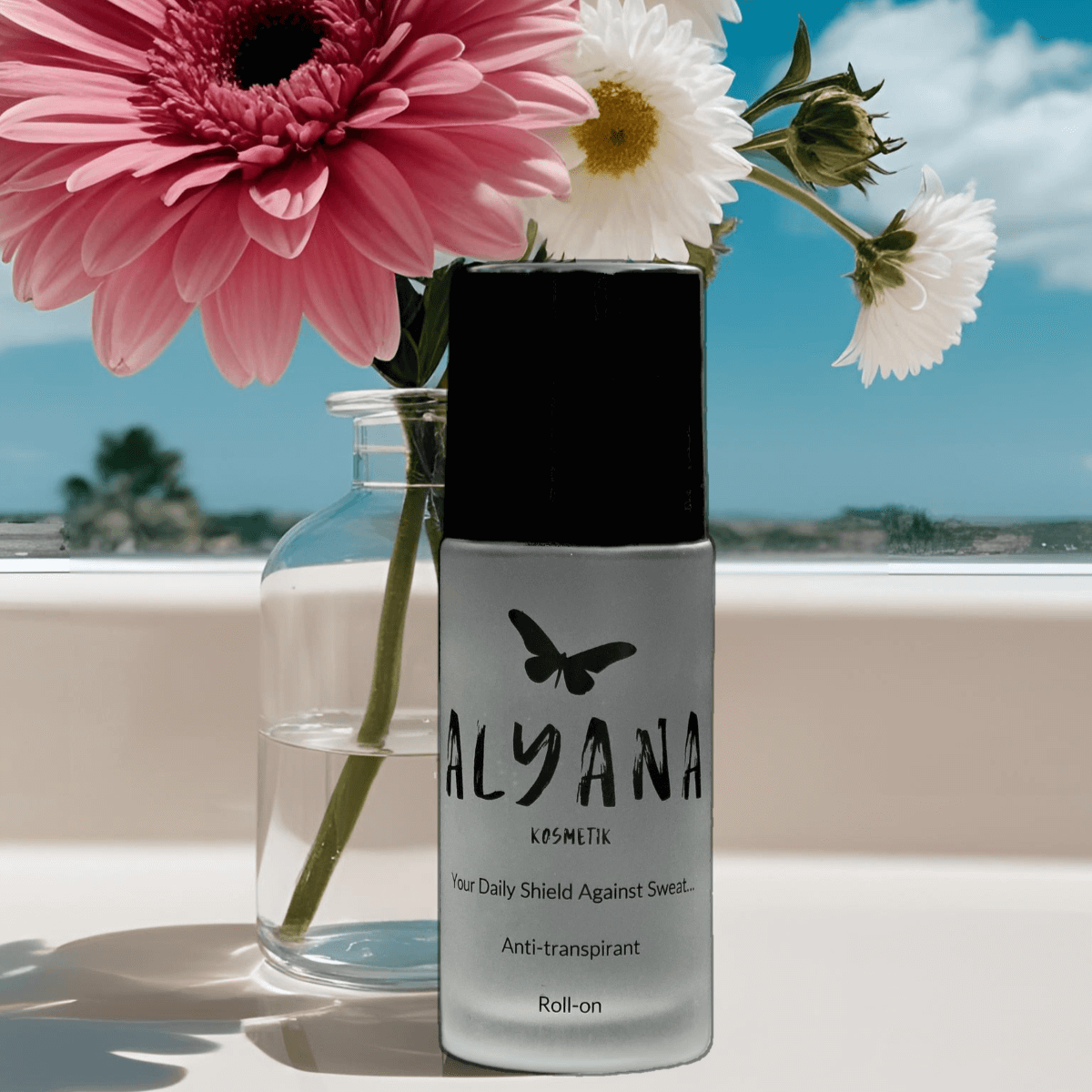 Alyana Antitranspirant Roll-on bottle with flowers in the background, promoting effective sweat protection.